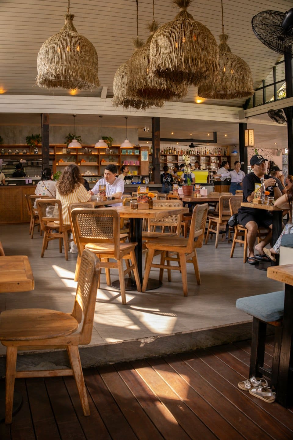 People dine and socialize at tables in a modern cafe.